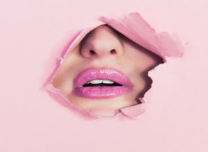 Lips behind pink paper - Ian Dooley